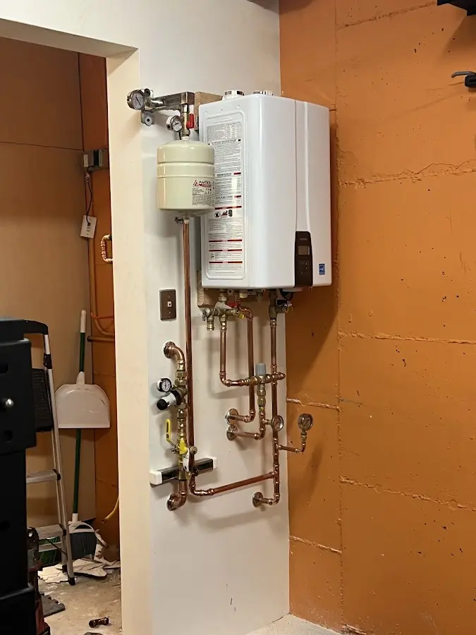Plumbing technician inspecting water heater connections in Sweetwater